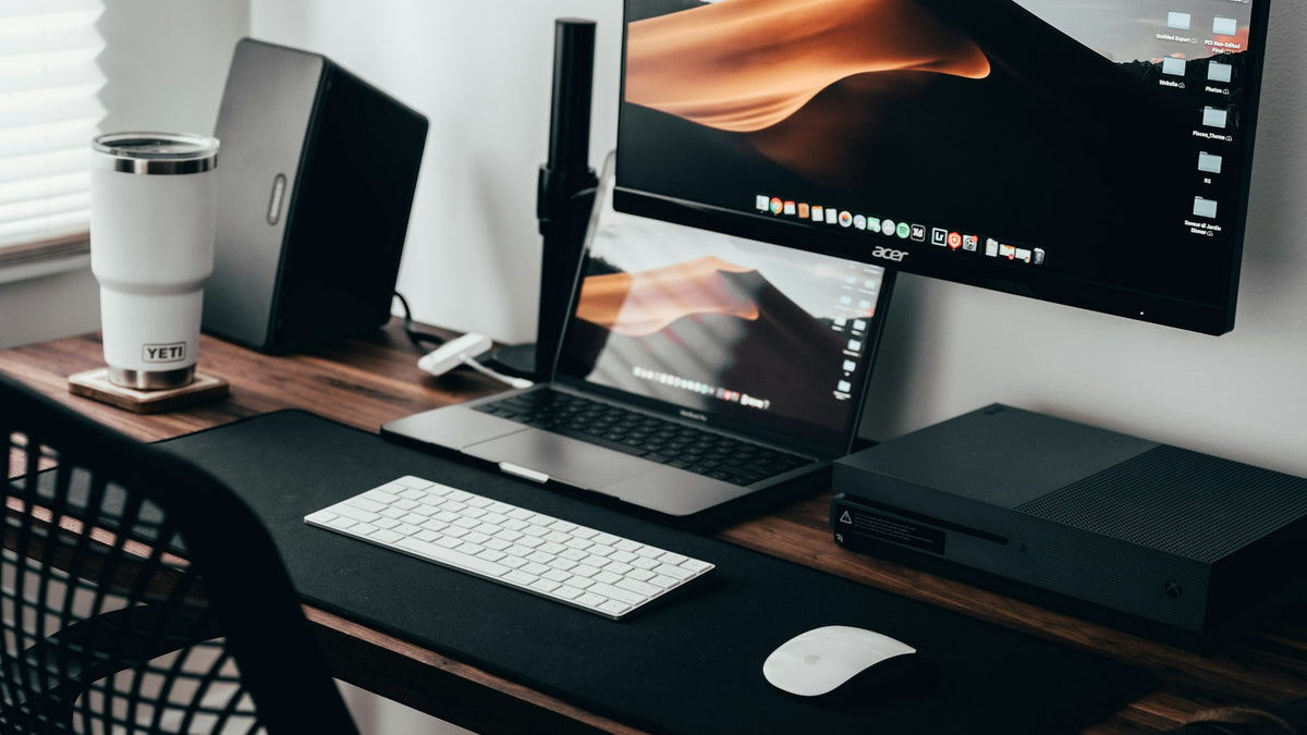 Escritorio de oficina en casa con laptop, monitor y teclado